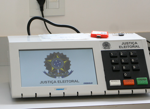 Urna Eletrônica, mostrando o Brasão da República ao iniciar seu funcionamento, Memória de Resultado de Votação e chave de urna.