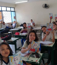 Crian&ccedil;as mostrando Cartilhas da Cidadania dentro de sala de aula