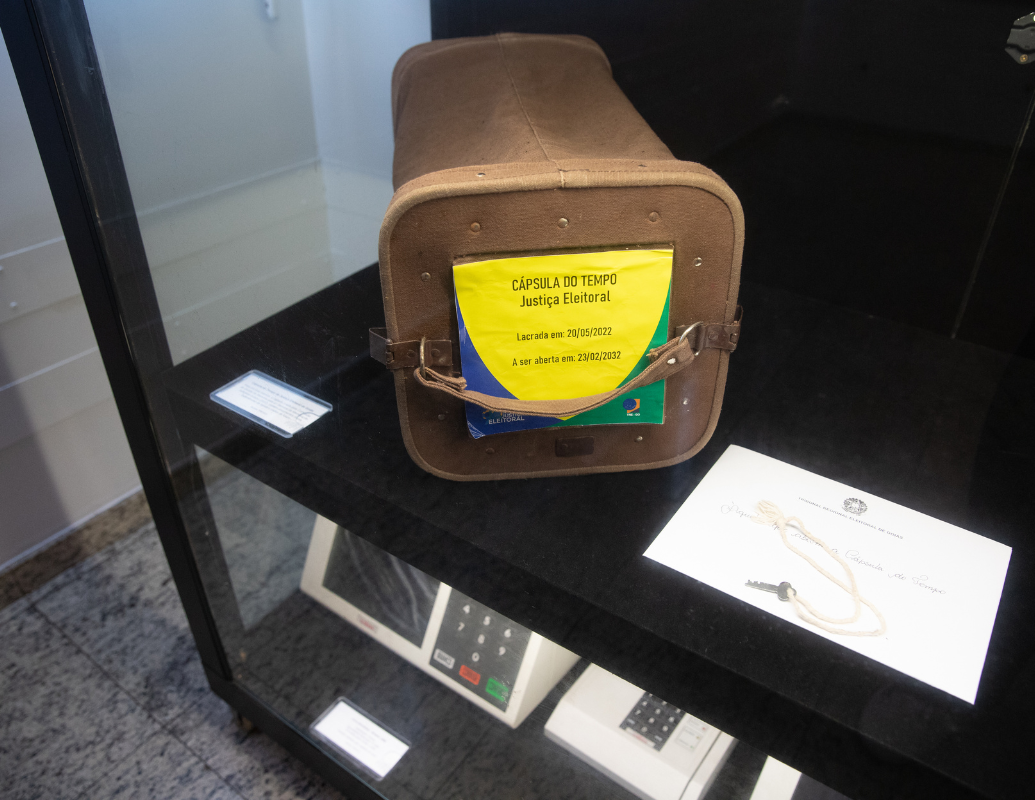 Cápsula do Tempo da Justiça Eleitoral de Goiás  Feita em lona marrom, a capsula criada pela Comissão  de Gestão da Memória para a I Semana da Memória do Judiciário Goiano (2022), contém documentos sobre experiências da época e visões de futuro.